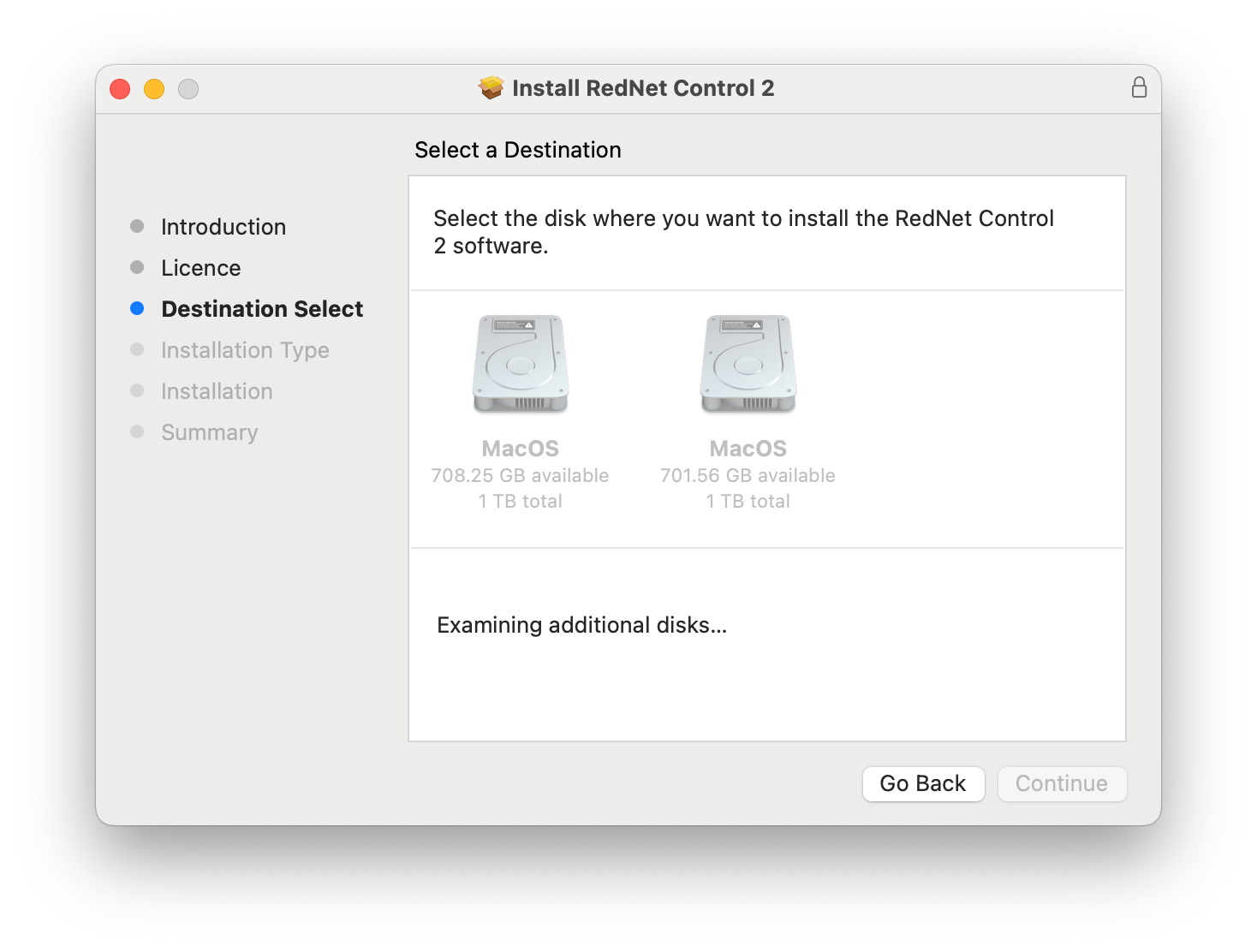 A screenshot of the RedNet Control 2 installer at the Destination Select stage. The installer reads, 'Select a Destination. Select the disk where you want to install the RedNet Control 2 software.' Two greyed out hard disk drive icons appear below, labelled identically, and with identical total space and available space. Beneath this, another message reads, 'Examining additional disks…' with a button to 'Go Back' and a greyed out 'Continue' button
